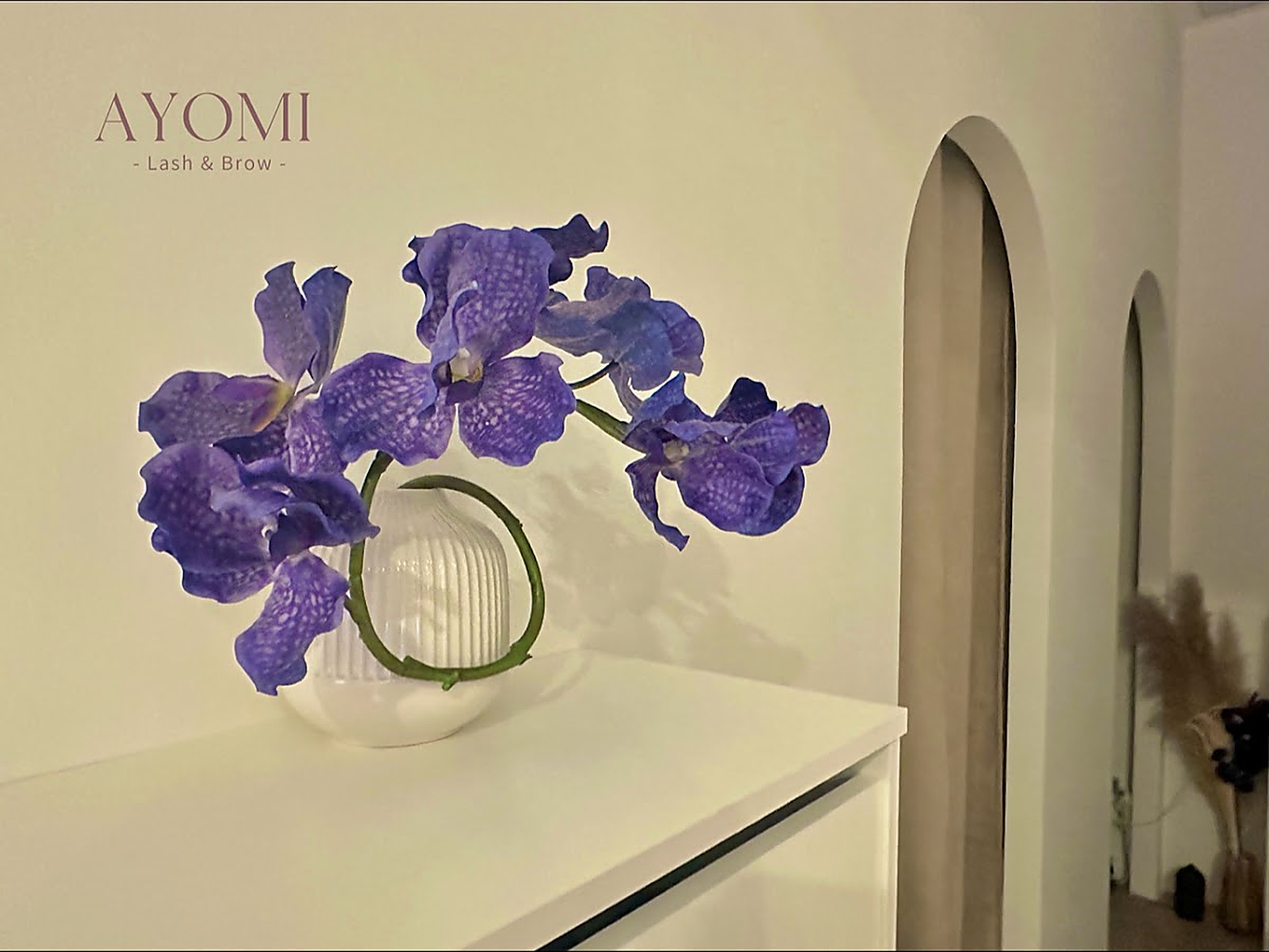 Ayomi Lash & Brow — quiet salon space with sculptural florals