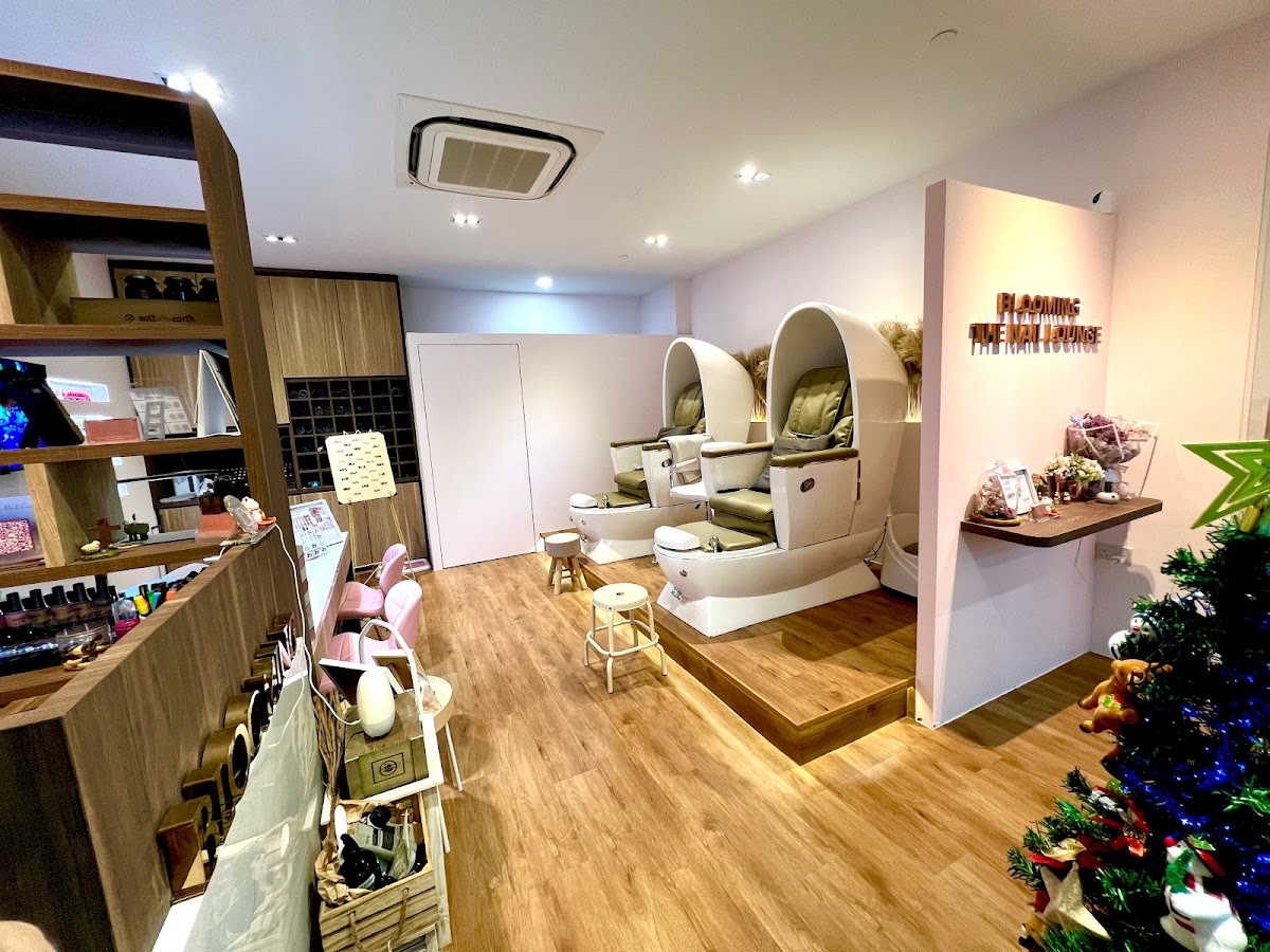 The modern_nail_pedicure_salon_interior of Blooming The Nail Lounge — warm wood, soft lighting, cream pod chairs.