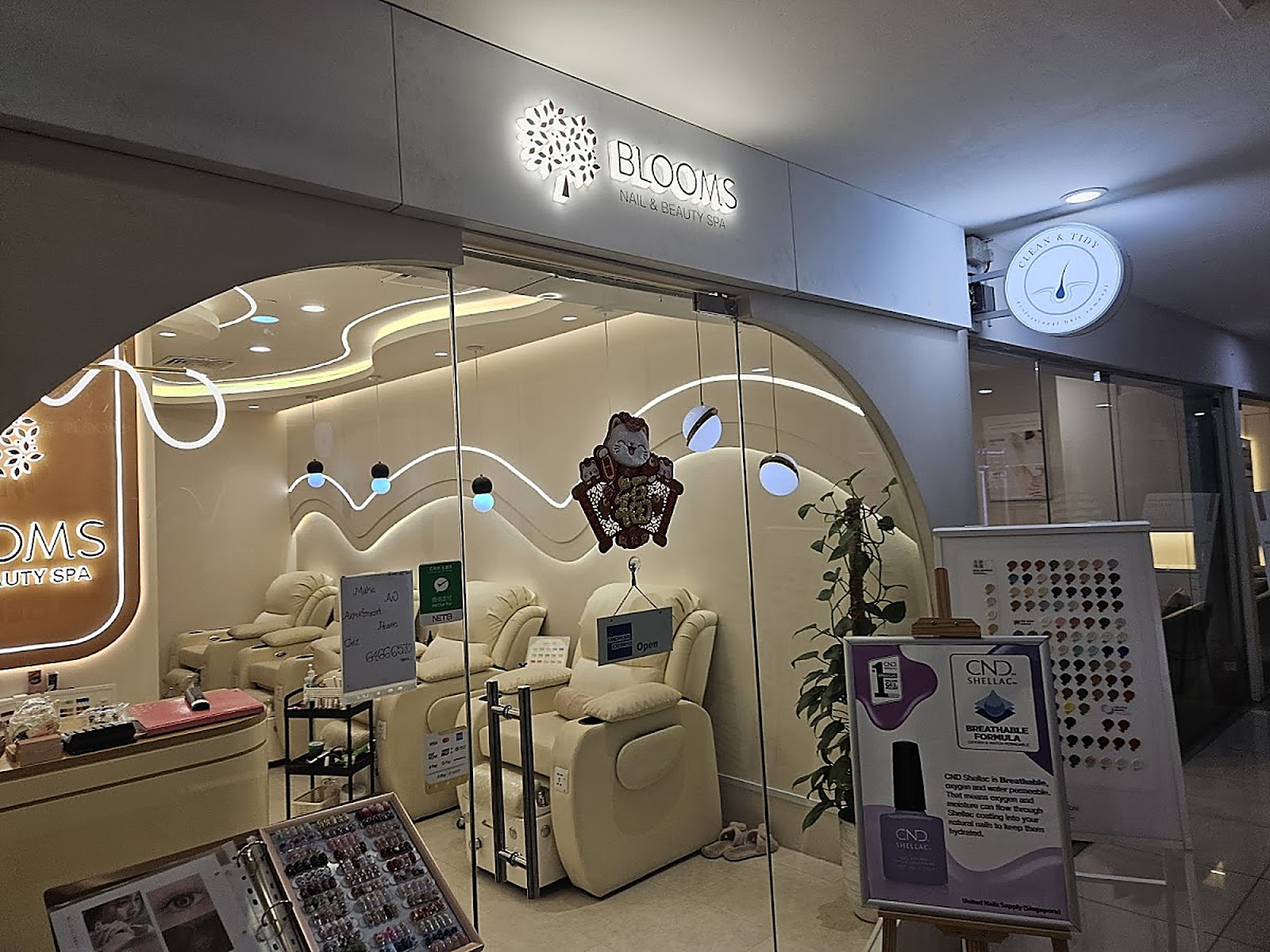 Modern nail spa interior at Blooms with soft cream tones and velvet recliners