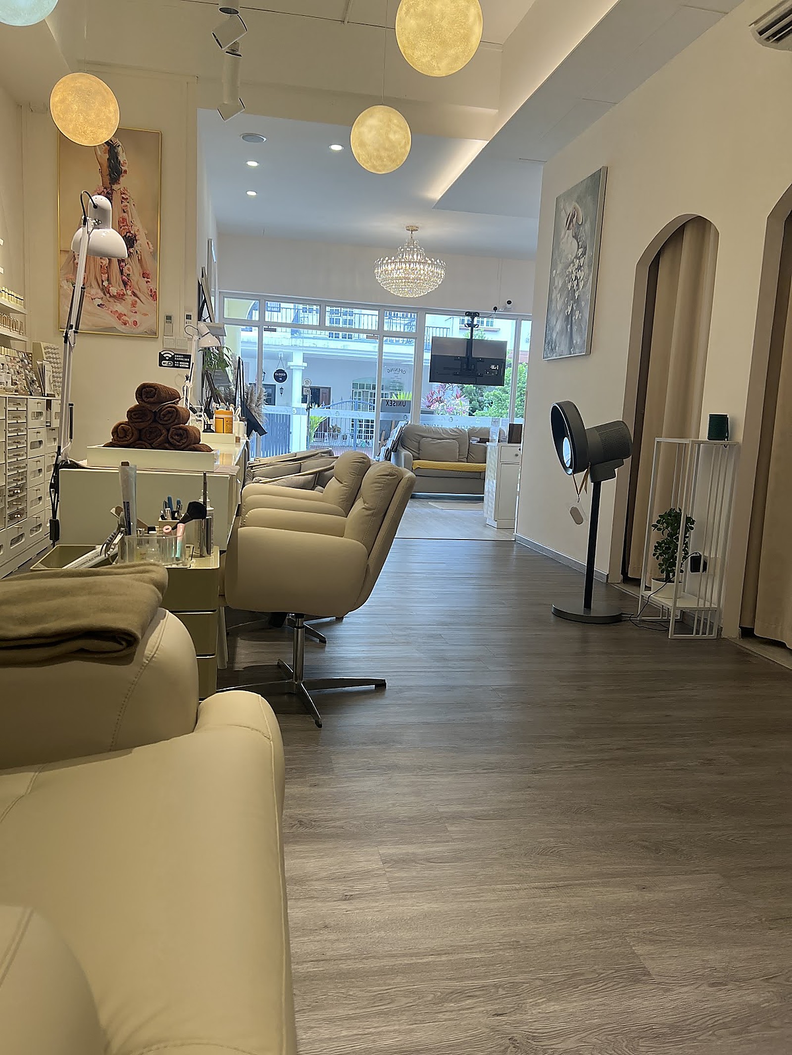 ELENURA modern salon interior with dove-grey recliner seating and warm globe pendant lighting