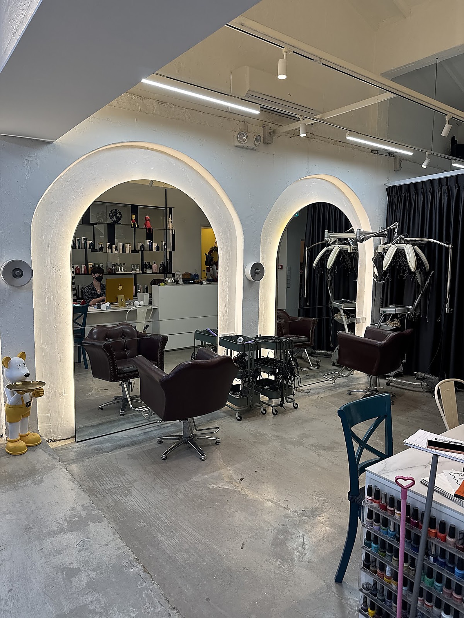 Modern salon interior with arched plaster walls and dark leather styling chairs