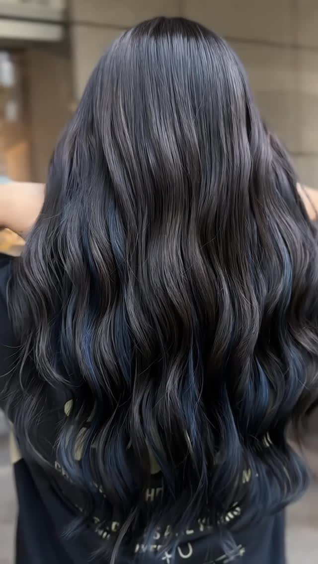 A finished long wavy dark hair look from inside Styles & Smiles Studio