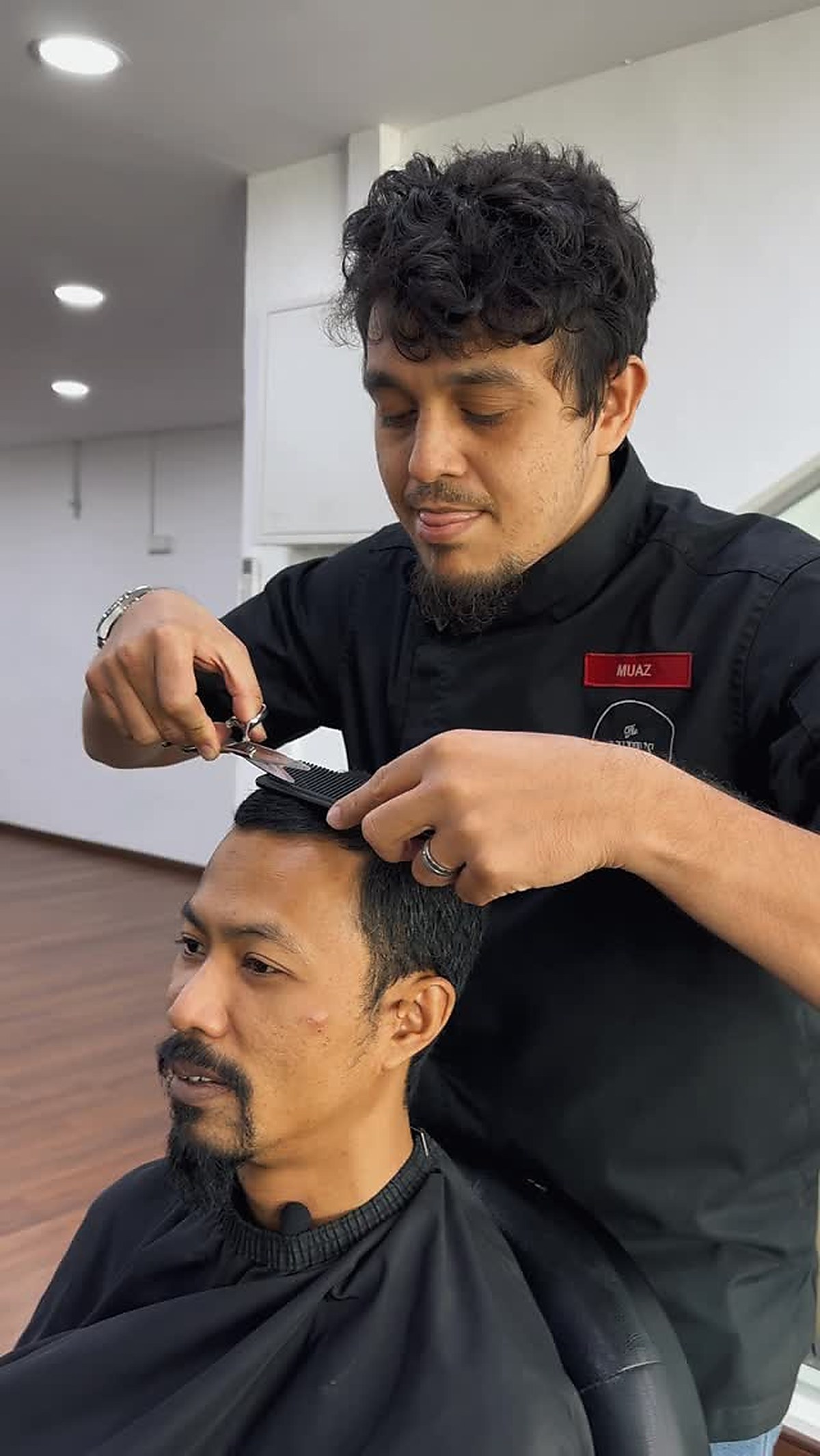 Barber demonstrating a haircut and finished styling
