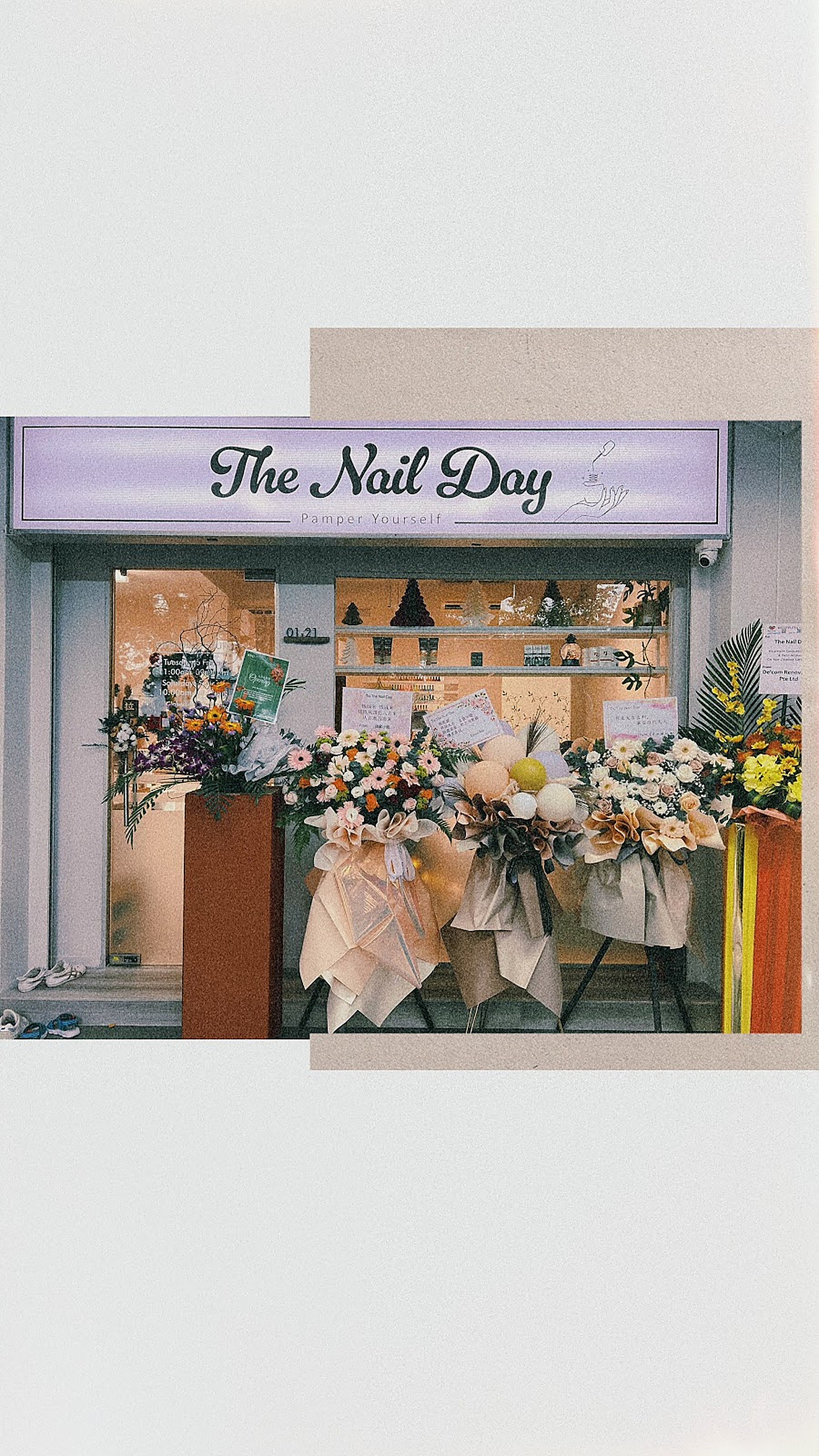 The Nail Day storefront softened with fresh florals
